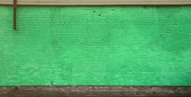 la textura de la pared de ladrillo de muchas filas de ladrillos pintados de color verde foto