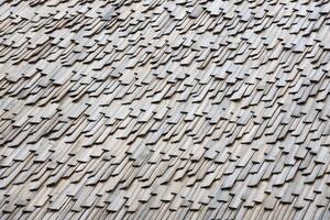 Gray wooden roof tiles background texture. A close up of old gray roof covered with wooden tiles photo