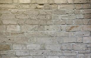 Very old brick stone wall of castle or fortress of 18th century. Full frame wall with obsolete dirty and cracked bricks photo