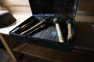 World War II fragmentation grenades stacked in a military box on wooden table in dark interior photo