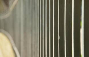 Close up view of a metal fence in perspective with blurred background photo