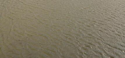 The texture of dark river water under the influence of wind, imprinted in perspective. Horizontal image photo