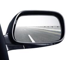 A rear view mirror with a picture of the road in it photo