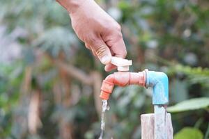 cerca arriba mano es torneado apagado grifo. concepto, salvar agua para ambiente. giro apagado grifo o grifo antes de partida. no lo hagas residuos agua por dejar eso goteo o goteando foto