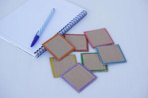 Paper cut in square shape with colorful frame, paper notebook and pen. Concept, teaching materials for adding texts or words for lessons or play games. Education design for learning subjects at school photo