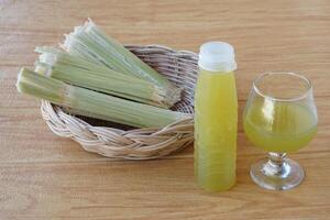 botellas de Fresco azúcar caña jugo. y bagazo después apretando para un bebida en cesta. concepto, sano natural bebida hecho desde agricultura cultivo. hecho en casa bebidas, tiene medicinal , herbario propiedades foto