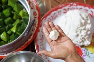 Hand hold flour bun ball for cooking traditional dessert. Concept, Thai food. How to cook, step of cooking. Thai traditional lifestyle, Prepare food for cultural celebration. photo