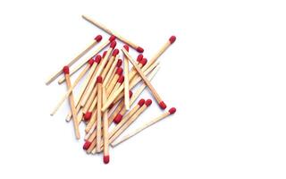 Pile of matches wooden sticks with red sulfur, scattered on white background. Concept, tool or equipment used for igniting fire made from small wooden sticks. with flammable substance on one end. photo