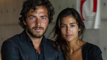 A man and a woman stand together posing for a photograph photo