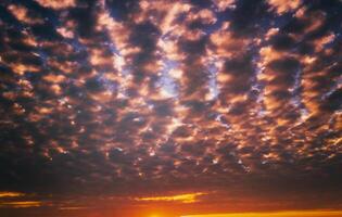 Dramatic cloudy sky illuminated by the rays at sunset or sunrise. Vintage film aesthetic. photo