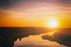 Sunrise or sunset on a lake or river with cloudy sky reflection in the water in summertime. Aesthetics of vintage film. photo