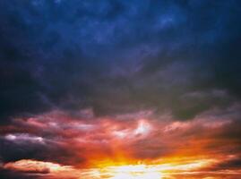 dramático nublado cielo iluminado por el rayos a puesta de sol o amanecer. Clásico película estético. foto