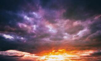 dramático nublado cielo iluminado por el rayos a puesta de sol o amanecer. Clásico película estético. foto