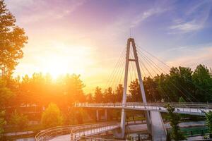 Modern footbridge across the Anhor canal in Navruz park at sunset in summertime, Uzbekistan, Tashkent. photo