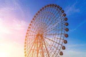 High ferris wheel at sunset or sunrise with cloudy sky background. photo