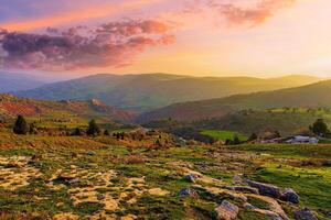 Foggy sunset or dawn in the mountains covered with grass and cloudy dramatic sky. photo