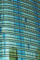 Fragment of a modern office building. Abstract geometric background. Part of a skyscraper with glass windows. photo