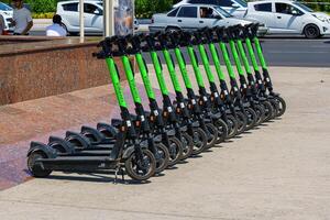 Tashkent, Uzbekistan - May 25, 2023 Rental of electric scooters parked on the sidewalk. photo