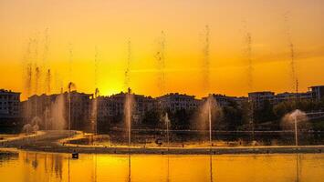 grande fuentes en el artificial estanque, iluminado por luz de sol a puesta de sol en Tashkent ciudad parque a Hora de verano. foto