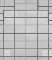 Black and white fragment of a modern office building. Abstract geometric background. Part of the facade of a skyscraper with glass windows. photo