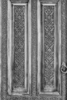 Carved wooden doors with patterns and mosaics. Black and white. photo