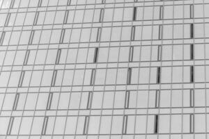 Fragment of a modern office building. Abstract geometric background. Part of the facade of a skyscraper with glass windows. Black and white. photo