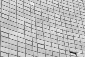 Black and white fragment of a modern office building. Abstract geometric background. Part of the facade of a skyscraper with glass windows. photo