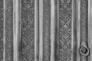 Carved wooden doors with patterns and mosaics. Black and white. photo