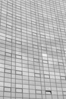 Black and white fragment of a modern office building. Abstract geometric background. Part of the facade of a skyscraper with glass windows. photo