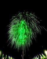 Colorful celebration fireworks isolated on a black sky background and waving flags of Uzbekistan. photo