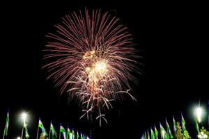 Colorful celebration fireworks isolated on a black sky background and waving flags of Uzbekistan. photo