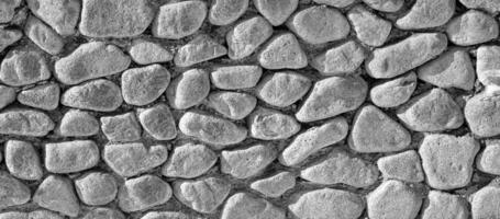 Black and white texture of an old antique stone wall. Abstract background. photo