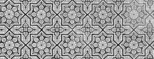 Black and white geometric traditional Islamic ornament on a tile. Fragment of a ceramic mosaic.Abstract background. photo