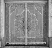 tallado de madera puertas con patrones y mosaicos negro y blanco. foto
