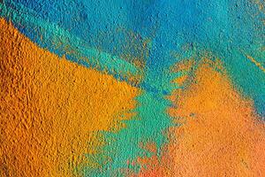 A fragment of colorful graffiti painted on a wall. Abstract urban background. Spray painting art. photo