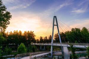 Modern footbridge across the Anhor canal in Navruz park at sunset in summertime, Uzbekistan, Tashkent. photo