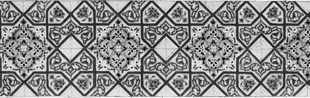 Black and white geometric traditional Islamic ornament on a tile. Fragment of a ceramic mosaic.Abstract background. photo