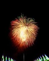 Colorful celebration fireworks isolated on a black sky background and waving flags of Uzbekistan. photo