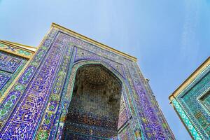 The ancient mausoleum of Shakh-I-Zinda, The Tomb of living King, during the reign of Amir Temur in Samarkand. Necropolis arch decorated with geometric Islamic oriental ornament. photo