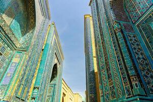 The ancient mausoleum of Shakh-I-Zinda, The Tomb of living King, during the reign of Amir Temur in Samarkand. Necropolis arch decorated with geometric Islamic oriental ornament. photo