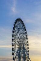 High ferris wheel at sunset or sunrise with cloudy sky background. photo