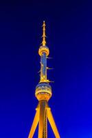 Tashkent television tower illuminated by night illumination at nighttime. photo