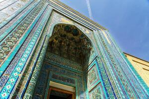 The ancient mausoleum of Shakh-I-Zinda, The Tomb of living King, during the reign of Amir Temur in Samarkand. Necropolis arch decorated with geometric Islamic oriental ornament. photo