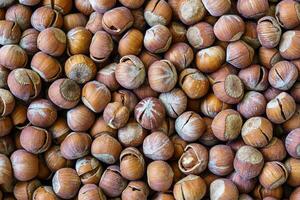 The texture of a heap of hazelnuts in the shell. Background of healthy plant vegan food. Nuts. photo