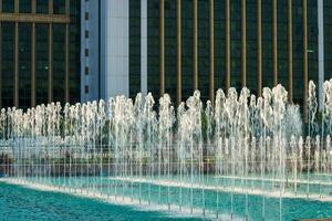 Fountains illuminated by sunlight at sunset or sunrise in the park at summertime. photo