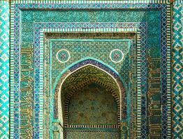 The ancient mausoleum of Shakh-I-Zinda, The Tomb of living King, during the reign of Amir Temur in Samarkand. Necropolis arch decorated with geometric Islamic oriental ornament. photo