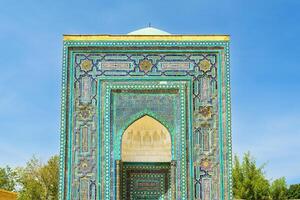 The ancient mausoleum of Shakh-I-Zinda, The Tomb of living King, during the reign of Amir Temur in Samarkand. Necropolis arch decorated with geometric Islamic oriental ornament. photo