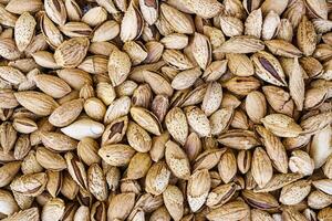 The texture of a heap of almonds in a shell. Background of healthy plant vegan food. Nuts. photo