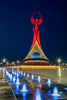 UZBEKISTAN, TASHKENT - MAY 5, 2023 Illuminated monument of independence in the form of a stele with a Humo bird, fountains and waving flags in the New Uzbekistan park at nighttime. photo