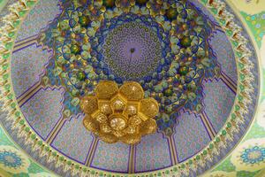 Geometric traditional Islamic ornament and domed ceiling chandelier. Fragment of a ceramic mosaic. photo